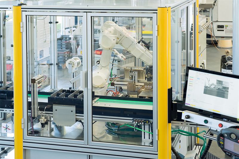 Automatisierte Fertigungszelle mit Roboterarm bei STEGER