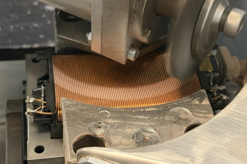 Bürstmaschine im Einsatz: Die Kupferwicklung des Modellbahn-Fahrreglers wird gebürstet, damit sie – ähnlich einem Potentiometer – abgreifbar ist